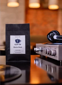 Electro Roast coffee bag next to modern audio equipment, blending high-quality coffee with the lifestyle of a music enthusiast.