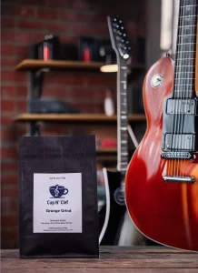 Grunge Grind coffee bag placed in a music studio setting with guitars, emphasizing bold and smoky flavors.